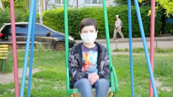 一个骑着蒙面秋千的男孩 检疫结束 — 图库视频影像