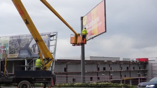 Man Descends Lift Posting Billboards Crane — Stock Video