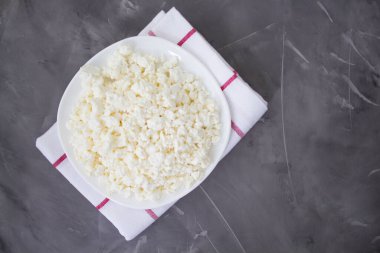 Beton bir arka planda taze süzme peynir tabağı. Sağlıklı yiyecekler. Organik süzme peynir. Keto diyeti. Makro. Yukarıdan bak. Kopyalama alanı