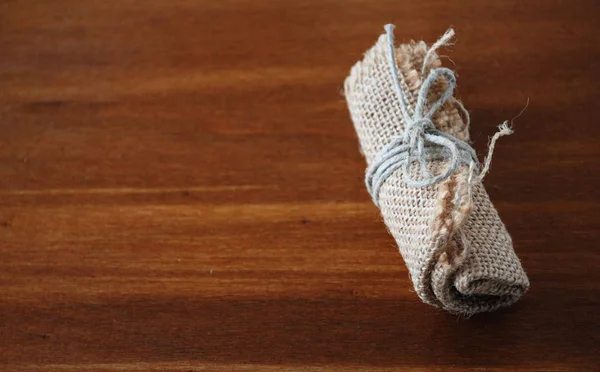 Paquete de arpillera sobre mesa de madera — Foto de Stock