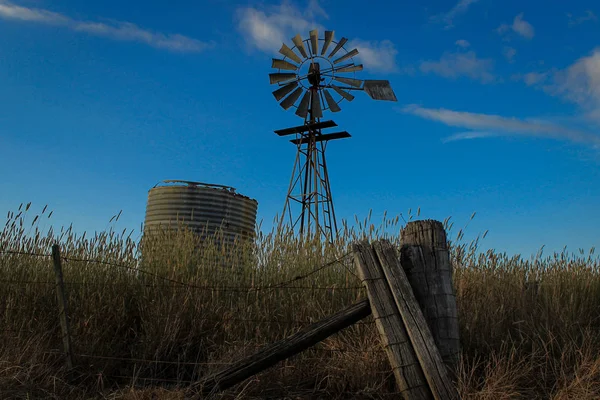 Stara fenceline, zbiornik wodny i wiatrak na wsi w Australii — Zdjęcie stockowe