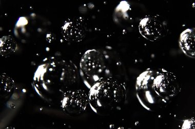 siyah bir arka plan karşı suda yüzen baubles