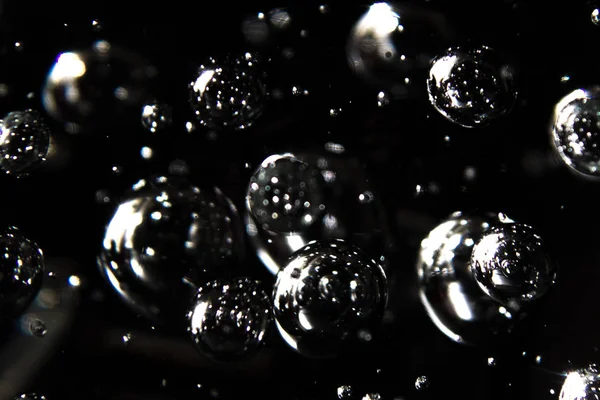 siyah bir arka plan karşı suda yüzen baubles