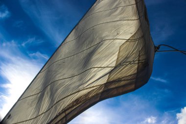 Beyaz yelken mavi bir gökyüzüne karşı çırparak