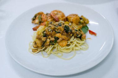 Leziz spagetti karides ve fesleğen beyaz tabakta ve 