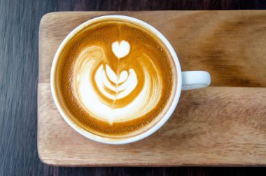 Kahve güzel Latte ile sanat siyah ahşap plaka üzerinde 