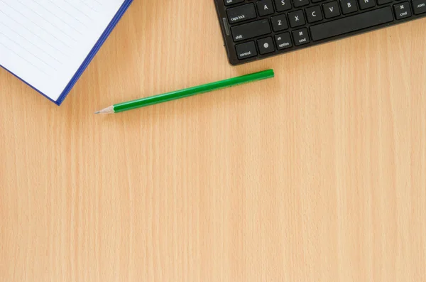 Notizbuch und grüner Bleistift und schwarze Tastatur in Buchenfarbe — Stockfoto