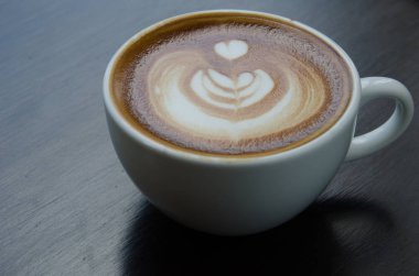 Beyaz fincan kahve güzel Latte ile sanat siyah arka plan üzerine
