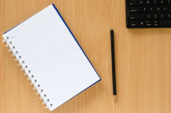 Carnet blanc et crayon noir et clavier noir sur hêtre co Images De Stock Libres De Droits