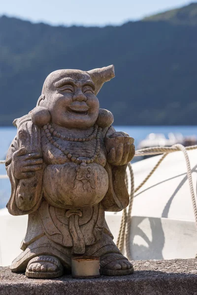 惠比寿在湖岸的木制雕像. — 图库照片