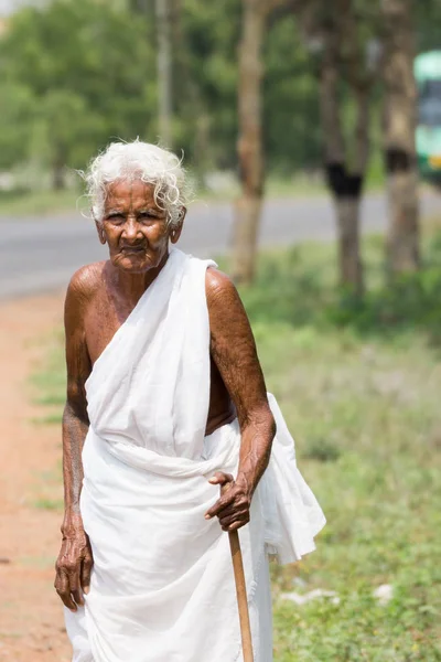 Old lady, a widow dressed in white along street. — Stock Photo, Image