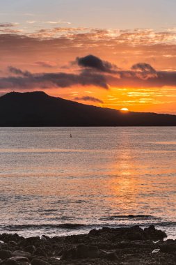 Sunrise Rangitoto volkan Auckland yakınındaki üzerinden yarım güneş gösterir.