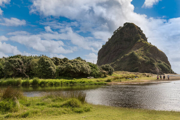 Lion rock on Piha Beach seen from creek.