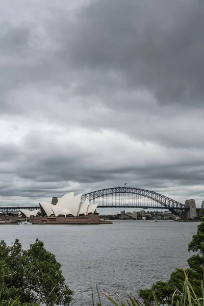 Opera House y el puente del puerto detrás bajo el paisaje nublado, Sydney A — Foto de Stock