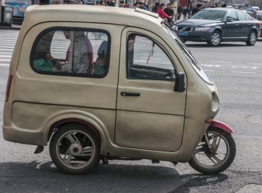 Küp benzeri üç tekerlekli bisiklet sokak sahnesinde kaplı.
