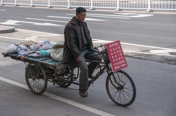 Man rides on freight tricycle in street scene. — Stock Photo, Image