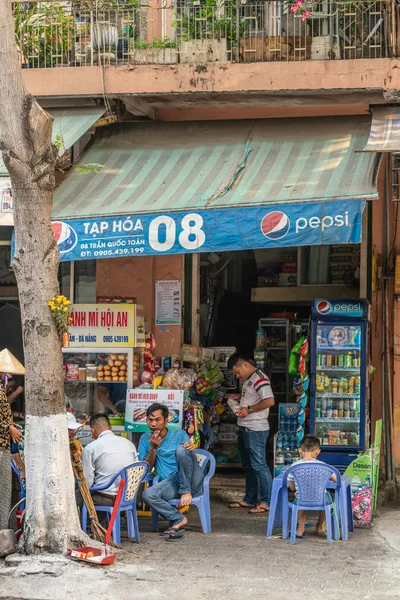 Άνδρες που κάθονται μπροστά από το μικρό βολικό κατάστημα, Da Nang Βιετνάμ. — Φωτογραφία Αρχείου