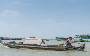 Cai Be, Vietnam yakınlarındaki Mekong Nehri 'nde yelkenli süren bir adam..