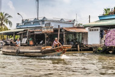 Cai Be, Mekong Delt 'te Kinh 28 kanalında motorlu şalopada iki adam.