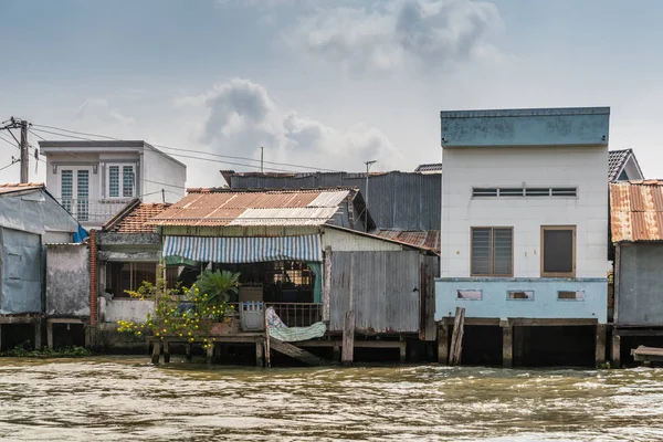 Row of simple houses along Kinh 28 canal in Cai Be, Mekong Delta