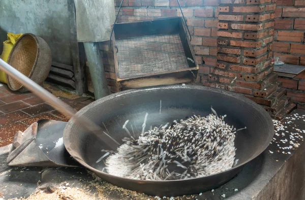 Černé rýžové jádra pop v černé vyhřívané pánvi v Cai Be, Meko — Stock fotografie