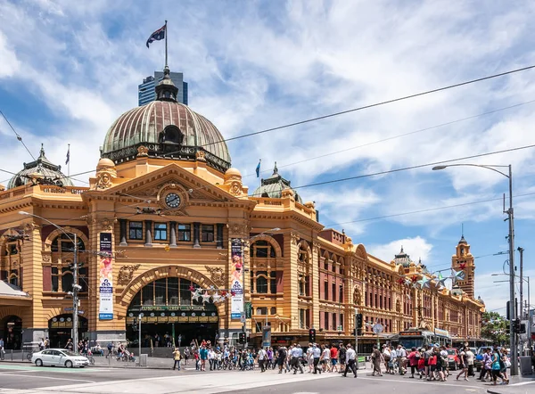 Decenas de personas cruzan la calle hacia la estación de tren de Flinders n M — Foto de Stock