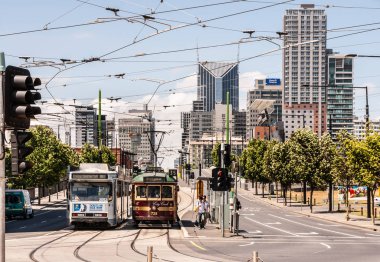 Melbourne, Avustralya 'da kavşakta 2 tramvaylı şehir manzarası.