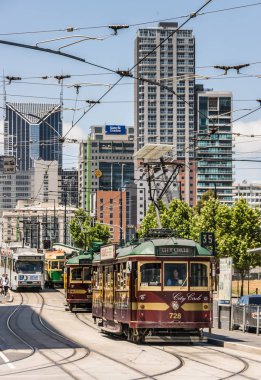 Melbourne kavşağında tramvayların ardışık olduğu şehir manzarası,