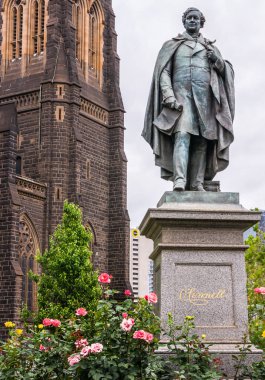 O Connell bronz heykeli ile kahverengi kilise duvarı, Melbourne, Austr
