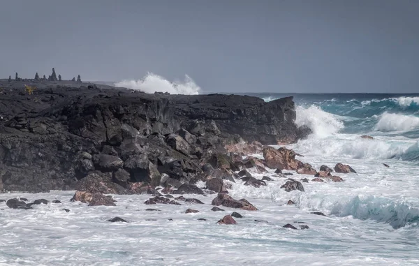 Las olas azules se estrellan en la costa de lava negra en Kaimu Beach, Hawái, EE. UU. — Foto de Stock