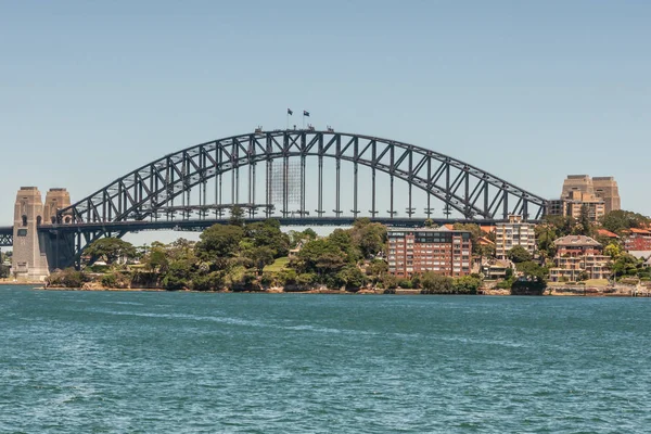 澳大利亚悉尼 2009年12月11日 海港大桥 全金属跨度 船首和石锚塔 与蓝天和东海岸上方的绿色植被和建筑物 前面的蓝色海湾 — 图库照片