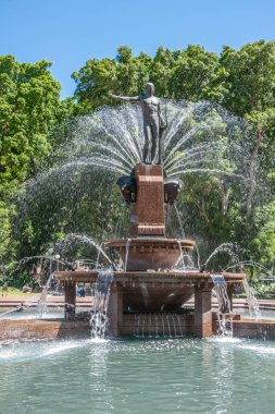 Sydney, Avustralya - 11 Aralık 2009: Archibald Çeşmesi 'ndeki insan heykelinin kapatılması. Dökülen su, yeşil yapraklar ve güneşteki insanlar..
