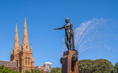 Sydney, Avustralya - 11 Aralık 2009: Apollo heykeli Archibald Çeşmesi 'nde faaliyet gösteriyor. Dökülen su, yeşil yapraklar, Aziz Mary Katedrali ve mavi gökyüzü..