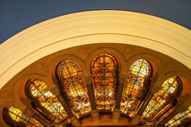 Sydney, Avustralya - 11 Aralık 2009: Queen Victoria alışveriş merkezinin içi. Sarı pruvanın altındaki sütunların arasına yerleştirilmiş sıcak renkli cam pencerelerin pruvasına yakın çekim.