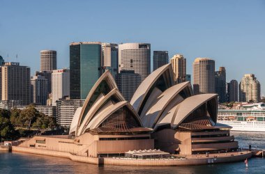 Sydney, Australia - December 11, 2009: Opera House. Closeup with business skyscrapers in back under blue sky.