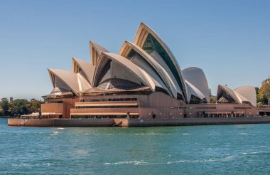 Sydney, Australia - December 11, 2009: Opera House. Water-level closeup of it under blue sky. Azure bay water in front.