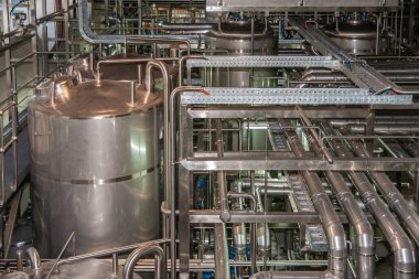 Brisbane, Australia - December 8, 2009: Castlemaine Perkins brewery. Intermediary tanks, plenty of pipelines for beer, water and CO2 in the filling processsing plant. All shine metal.