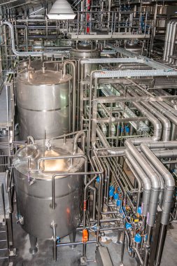 Brisbane, Australia - December 8, 2009: Castlemaine Perkins brewery. Portrait of Intermediary tanks, plenty of pipelines for beer, water and CO2 in the filling processsing plant. All shiny metal.