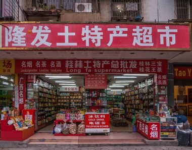 Guilin, China - May 9, 2010: Zhengyang pedestrian shopping street. Long Ta Supermarket frontal view. Mostly red and white colors. Open front with abundance of displayed merchandise.