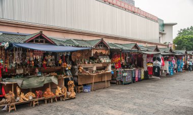 Guilin, Çin - 10 Mayıs 2010: şehir merkezi. Yeşil çatıları olan, yarı kalıcı kabinleri olan, hediyeler, giysiler ve daha fazlası satan bir sokak pazarı. Arkada uzun gri bir duvar var..