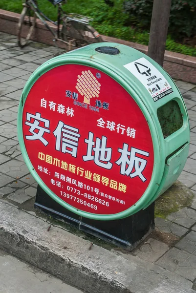 中国桂林 2010年5月10日 市中心 街道上红色和绿色垃圾桶的封堵 普通话拼音广告和后面的绿叶 — 图库照片