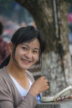 Guilin, Çin - 11 Mayıs 2010: şehir merkezi. Gülümseyen ve makyajını yapan genç bir kadın Li Nehri 'nin kenarında..