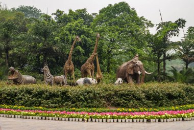 Chongqing, Çin - 9 Mayıs 2010: hayvanat bahçesi içinde veya hayvan parkında. Suaygırı, zebra, zürafa, panda, fil ve maymunun yeşil yeşillik ve çiçek ortamında yer aldığı heykel grubu..
