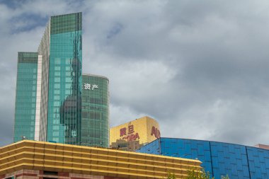 Şangay, Çin - 4 Mayıs 2010: Sarı ve mavi alt alışveriş merkezleri üzerindeki yeşil cam binalar, gri pelerin altındaki kongre merkezi binalar.