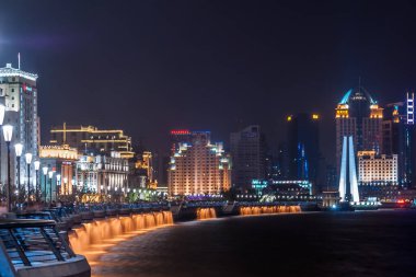 Şangay, Çin - 4 Mayıs 2010: Wusong nehri üzerindeki Waibaidu köprüsünde sona eren Huangpu Nehri boyunca Bund tahta yolunun gece fotoğrafı. Renkli ışıklandırılmış gökdelenli gökyüzü.