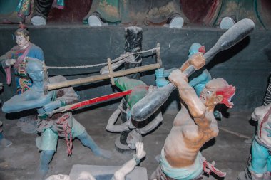 Fengdu, Çin - 8 Mayıs 2010 Hayalet Şehir, tarihi sığınak. İşkence sahnesinde bir kişi mavi şeytanlar tarafından ikiye bölünürken, bir diğeri kahverengi olan golf sopasını sallıyor..