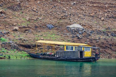 Wuchan, Çin - 7 Mayıs 2010: Daning Nehri 'ndeki Ejderha Kapısı Boğazı. Sarı yüzen feribotta Black yerel feribotu, kahverengi taş sarp kıyı şeridinde zümrüt yeşili su üzerinde sıçrama iskelesi.. 