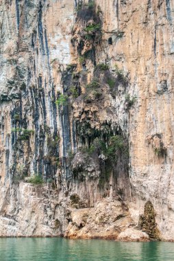 Wuchan, Çin - 7 Mayıs 2010: Daning Nehri üzerindeki Dawu veya Misty Gorge. Sarkıt sürüleri zümrüt geen suyunun üzerindeki mağaraların önünde kahverengi kayalıklar oluşturur..