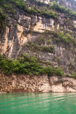 Wuchan, Çin - 7 Mayıs 2010: Daning Nehri üzerindeki Dawu veya Misty Gorge. Yol, zümrüt yeşili suyun üzerinde yeşil yapraklarla kahverengi-siyah kayalıklara bölünmüş..