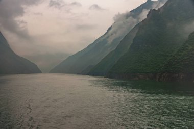 Baidicheng, Çin - 7 Mayıs 2010: Qutang Gorge, Yangtze Nehri. Manzara puslu kanyona doğru üzerlerinde gri bulutlar ve dağ yamaçları boyunca alçalan.